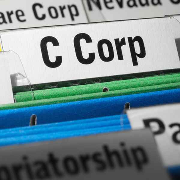 A close-up of file folders labeled with business structures, highlighting "C Corp."