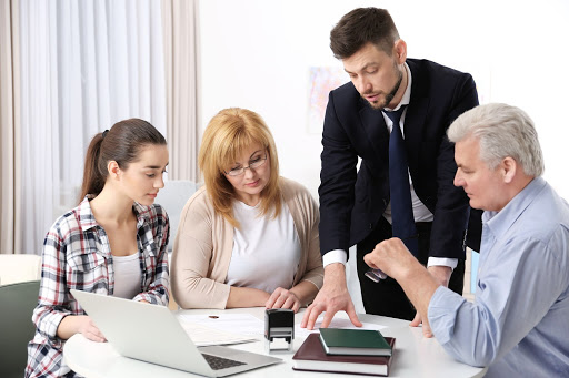 A lawyer explaining legal documents to a family at a table in an office setting.